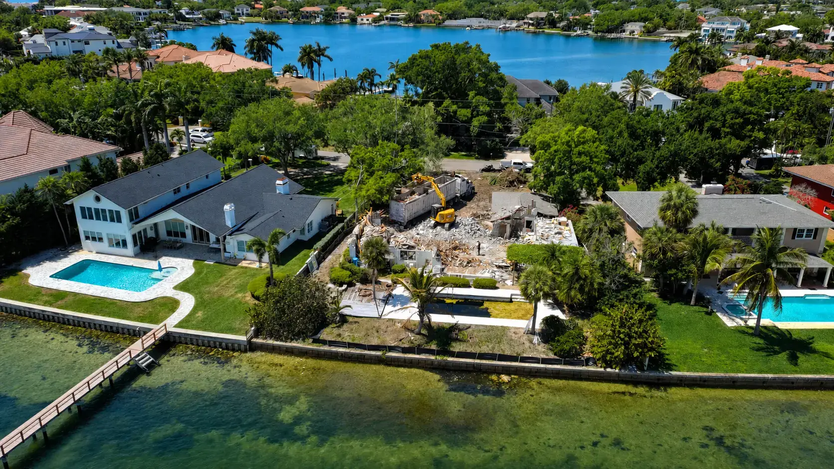 Demolition project positioned between neighboring waterfront homes